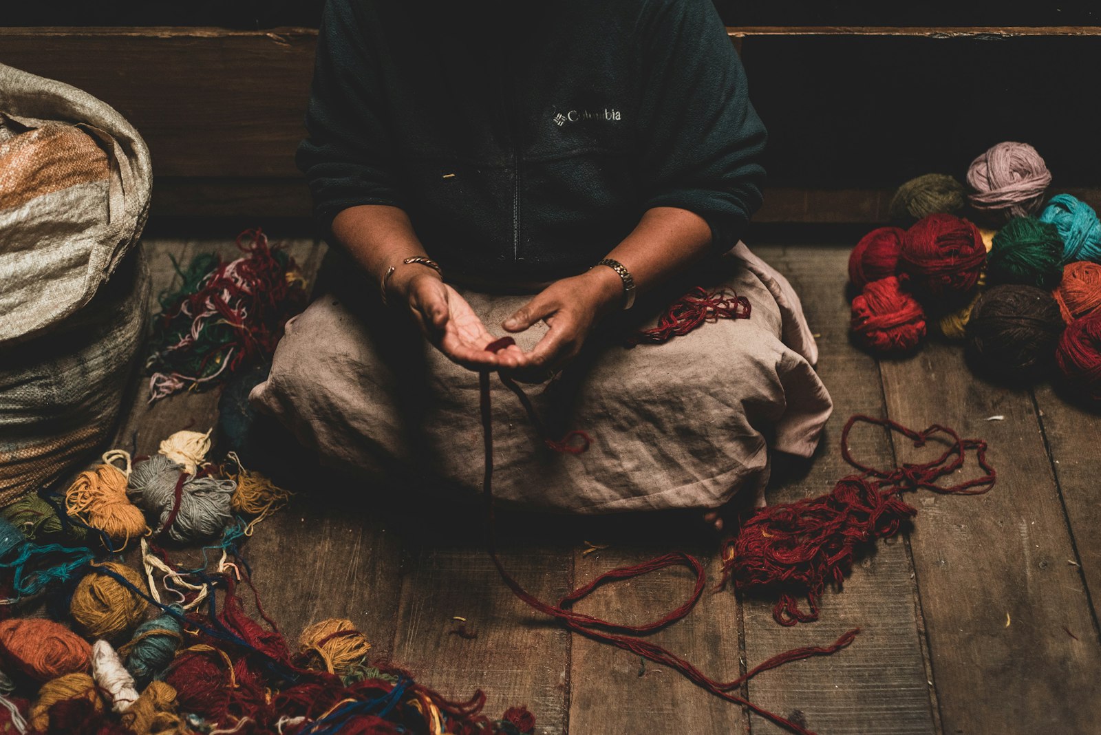 Manos trabajando lana artesanal española en proceso de hilado tradicional