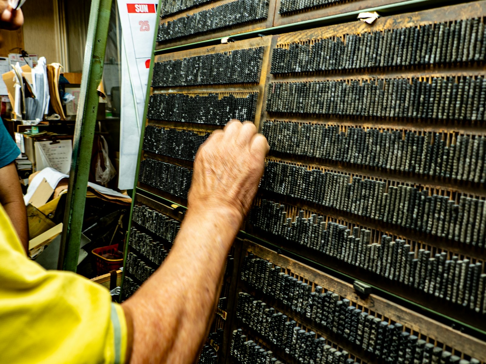 manos componiendo con tipos móviles en un taller de imprenta artesanal