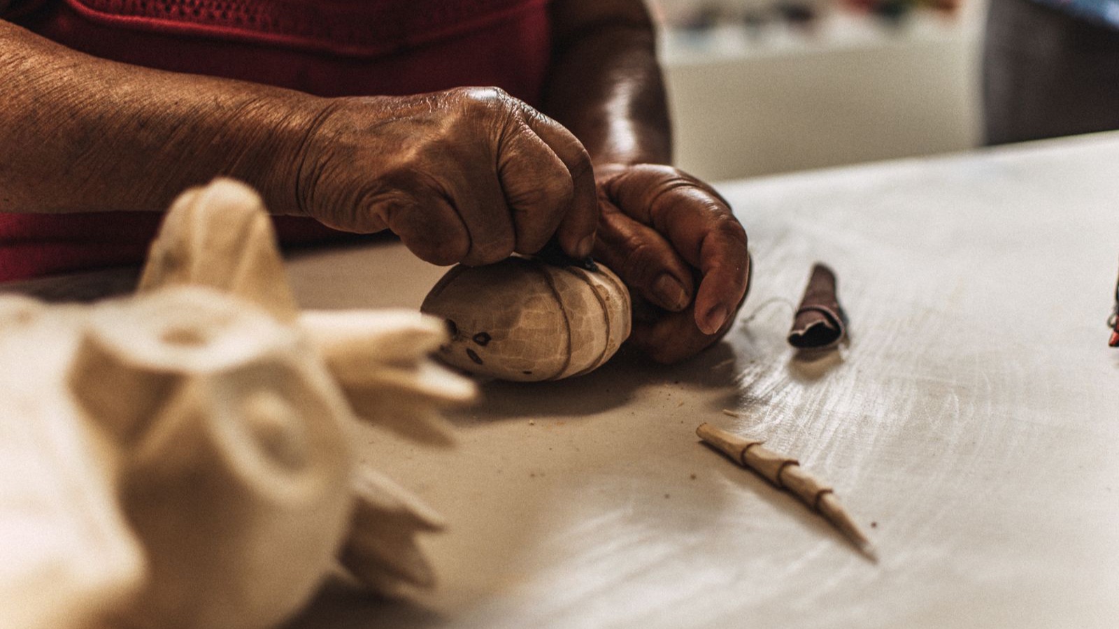Manos de artesano tallando madera